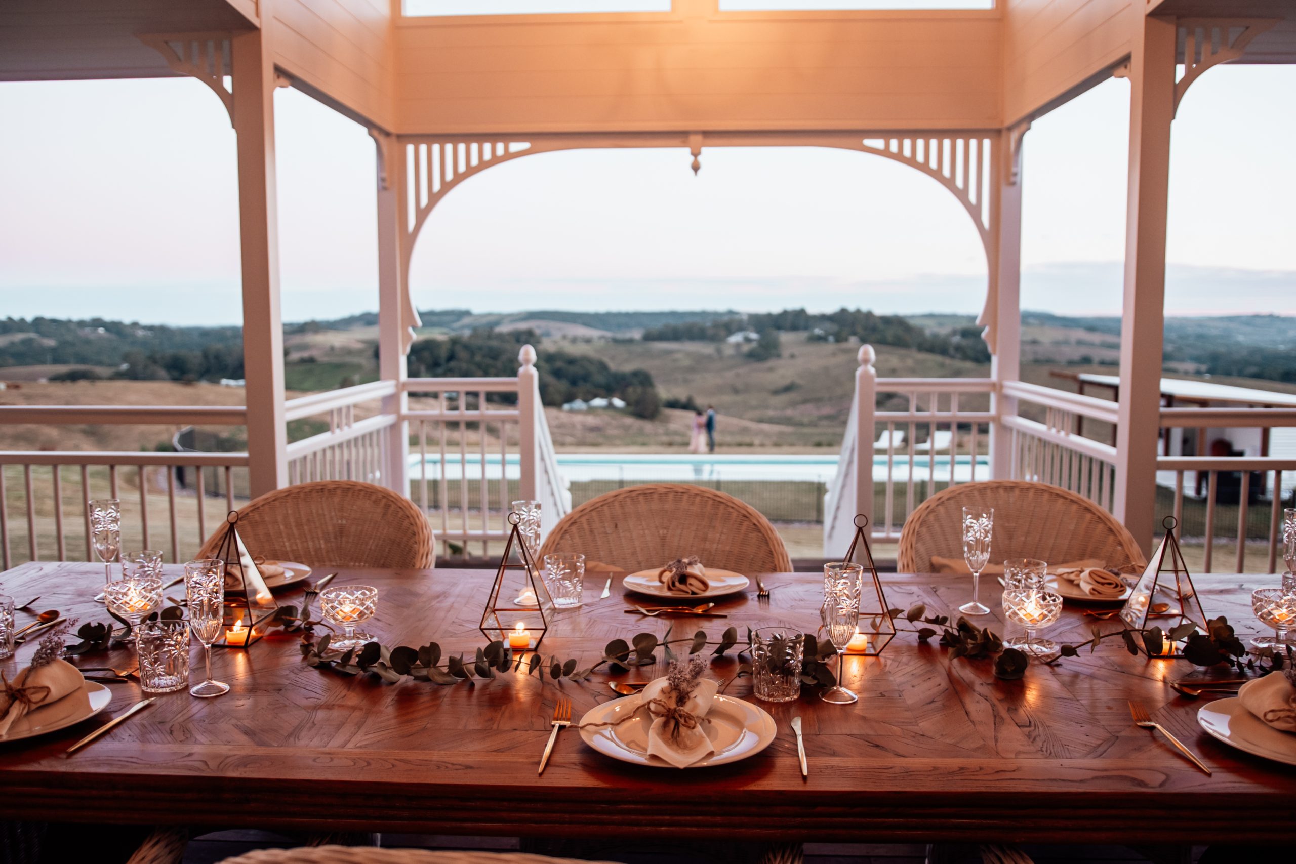 A dining setting at sunset at Aurora House on the back deck with sweeping hinterland views