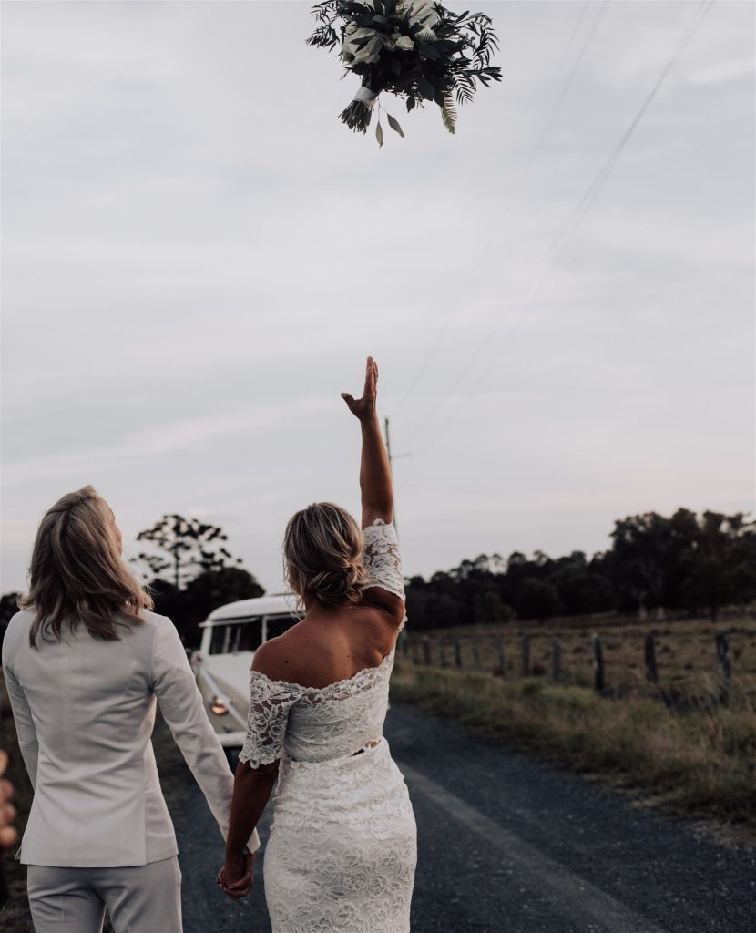 Two brides throwing a bouquet