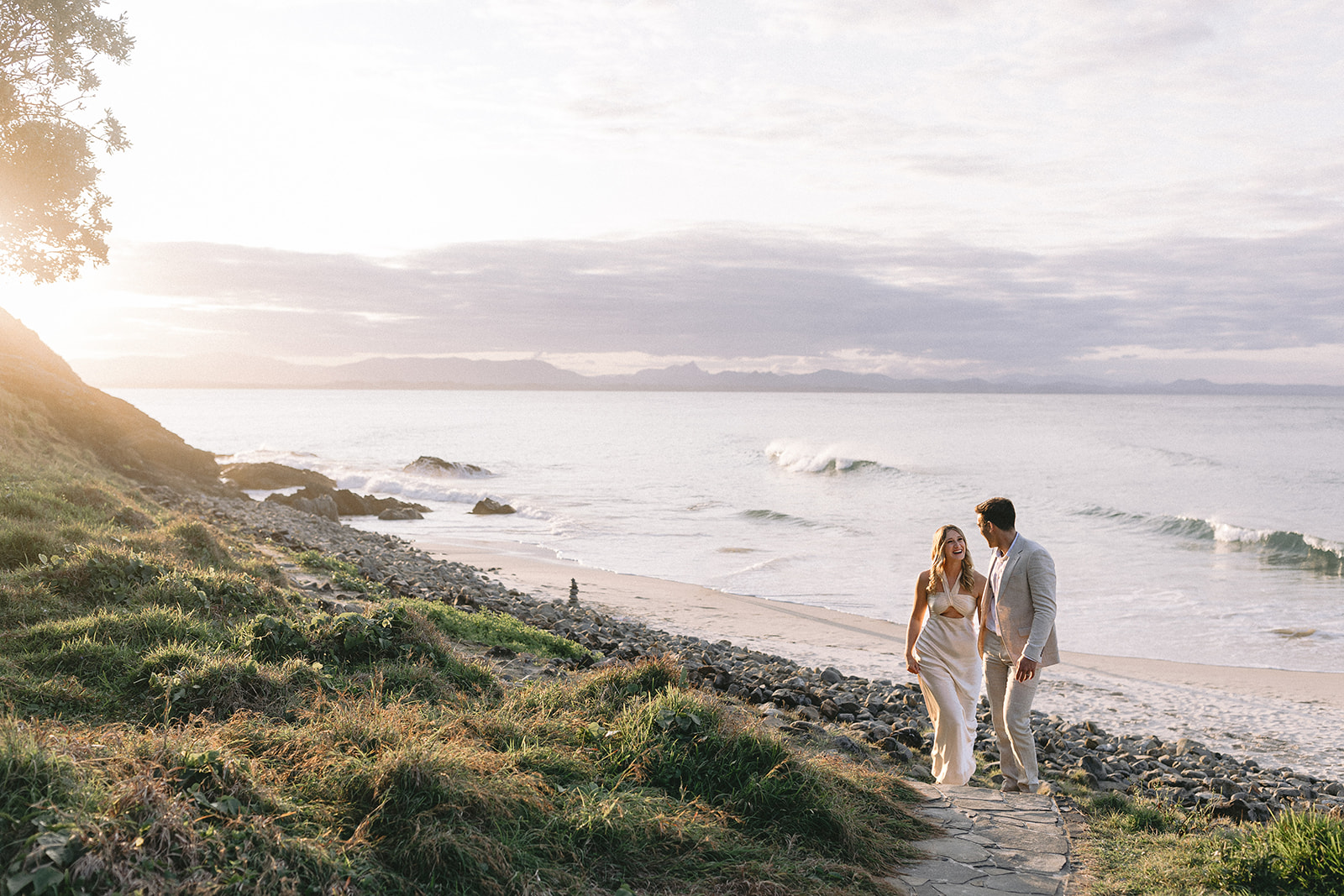 Bride and Groom walk at sunset on the wategos beach headland