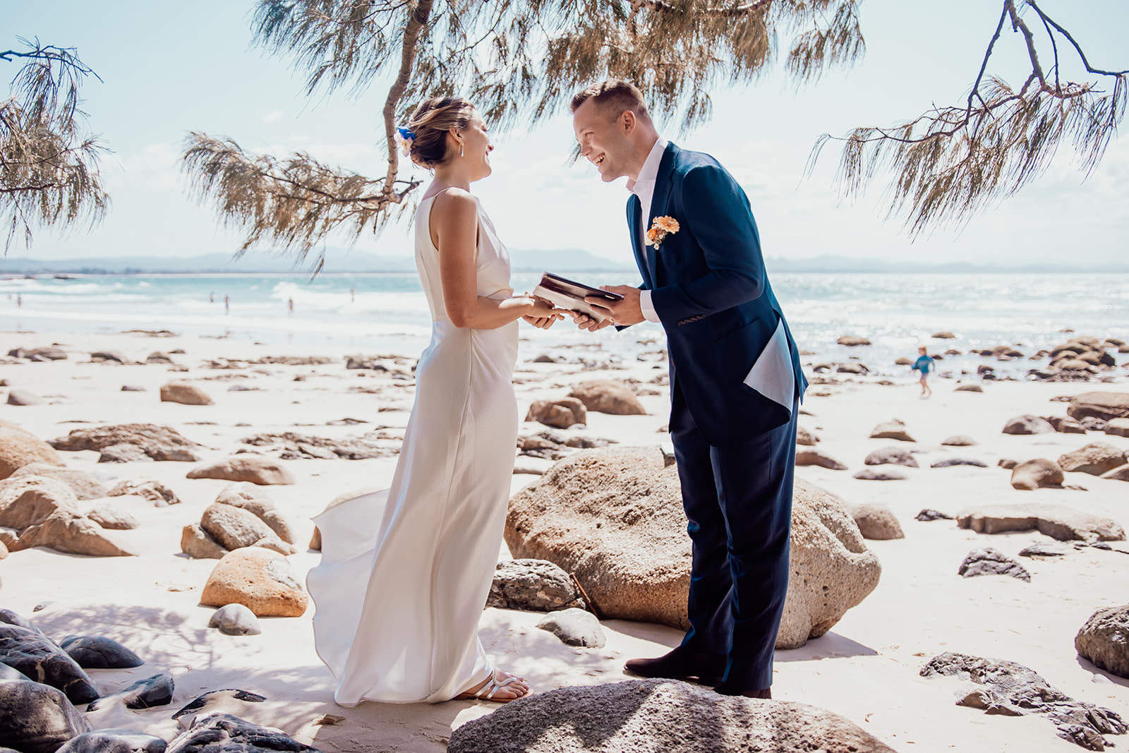 Bride and groom laughing sharing wedding vows at wategos beach